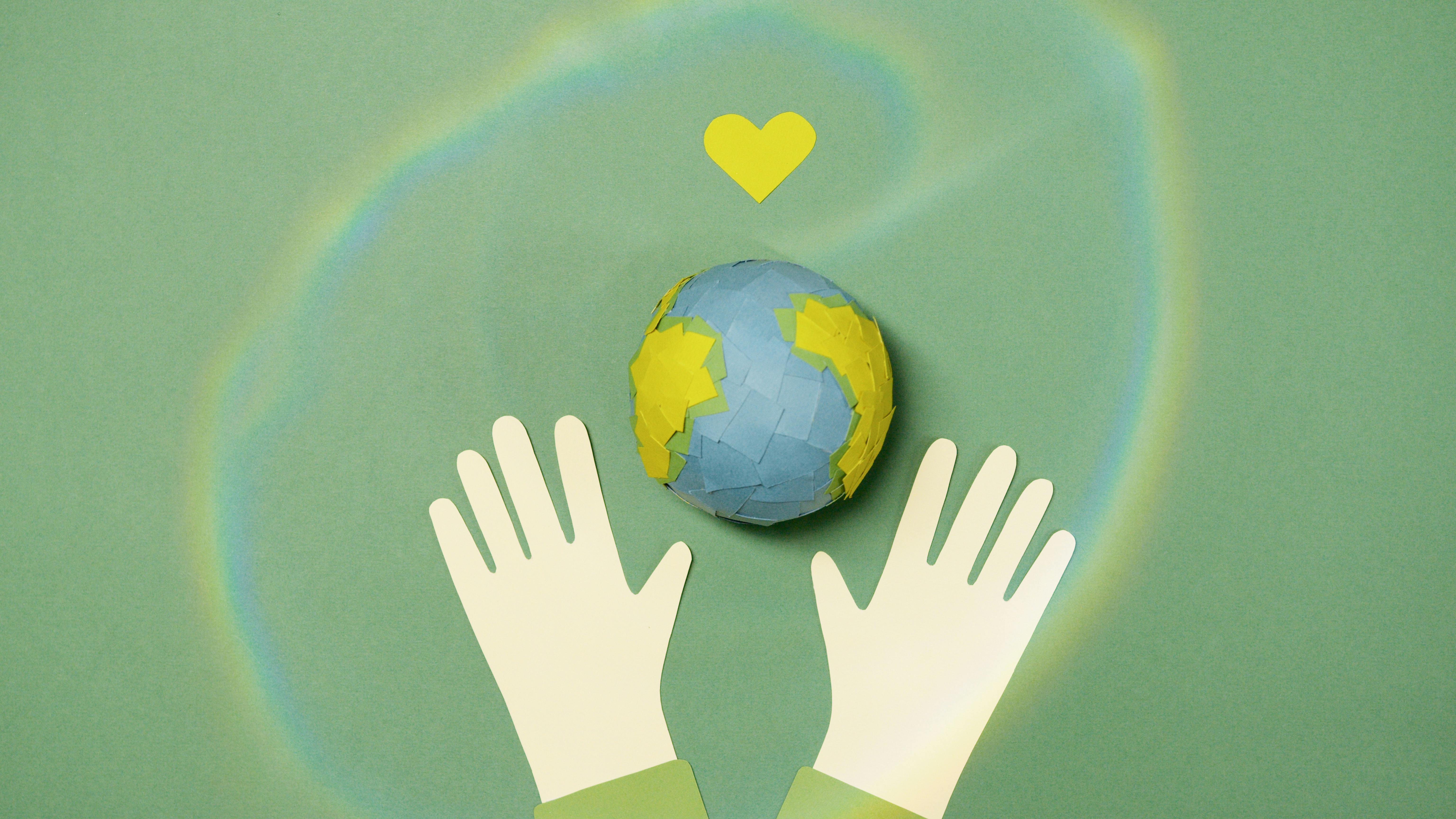 image of earth with a heart above it and gloved hands below