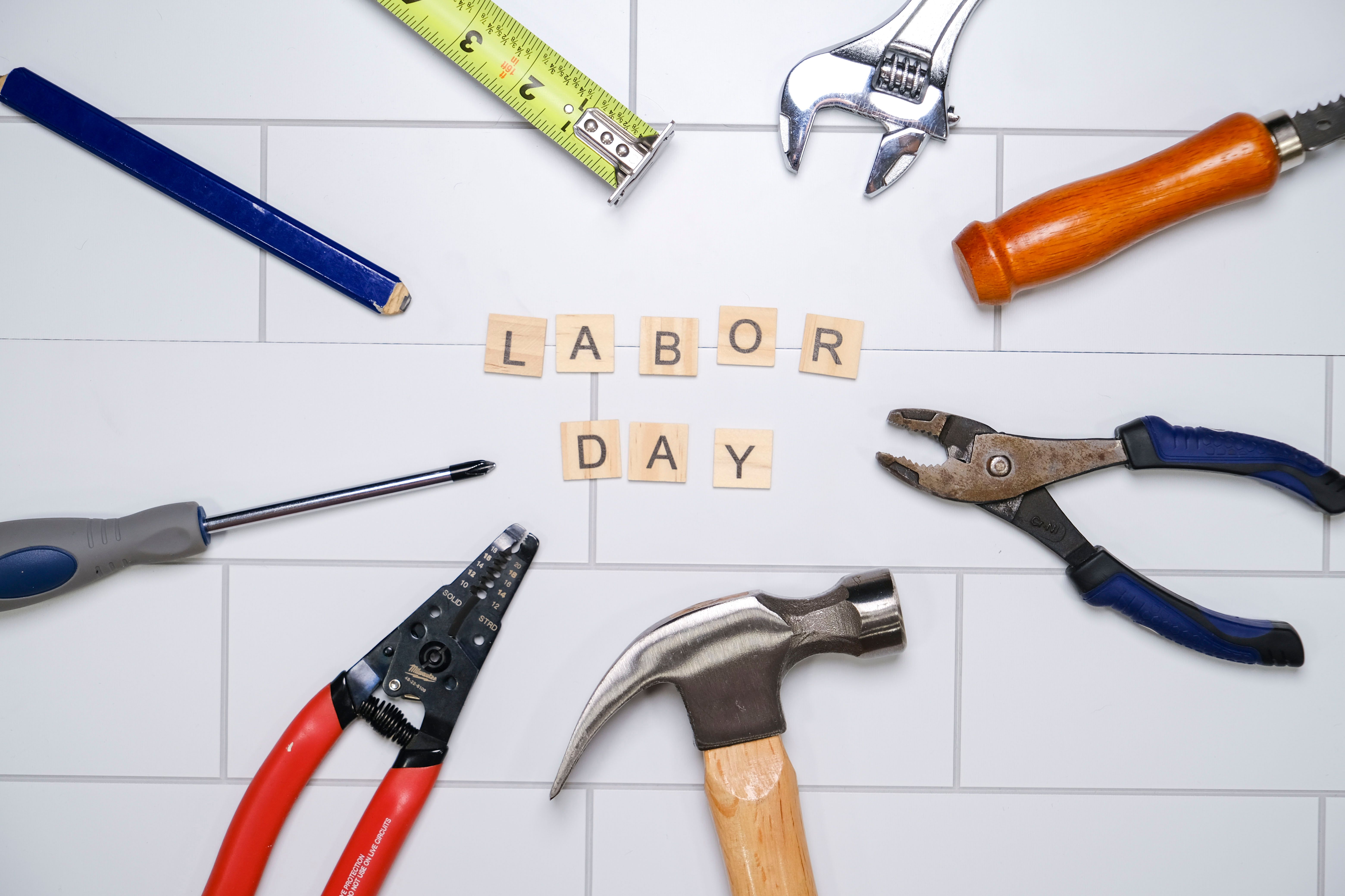 Labor Day spelled out on scrabble tiles surrounded by tools