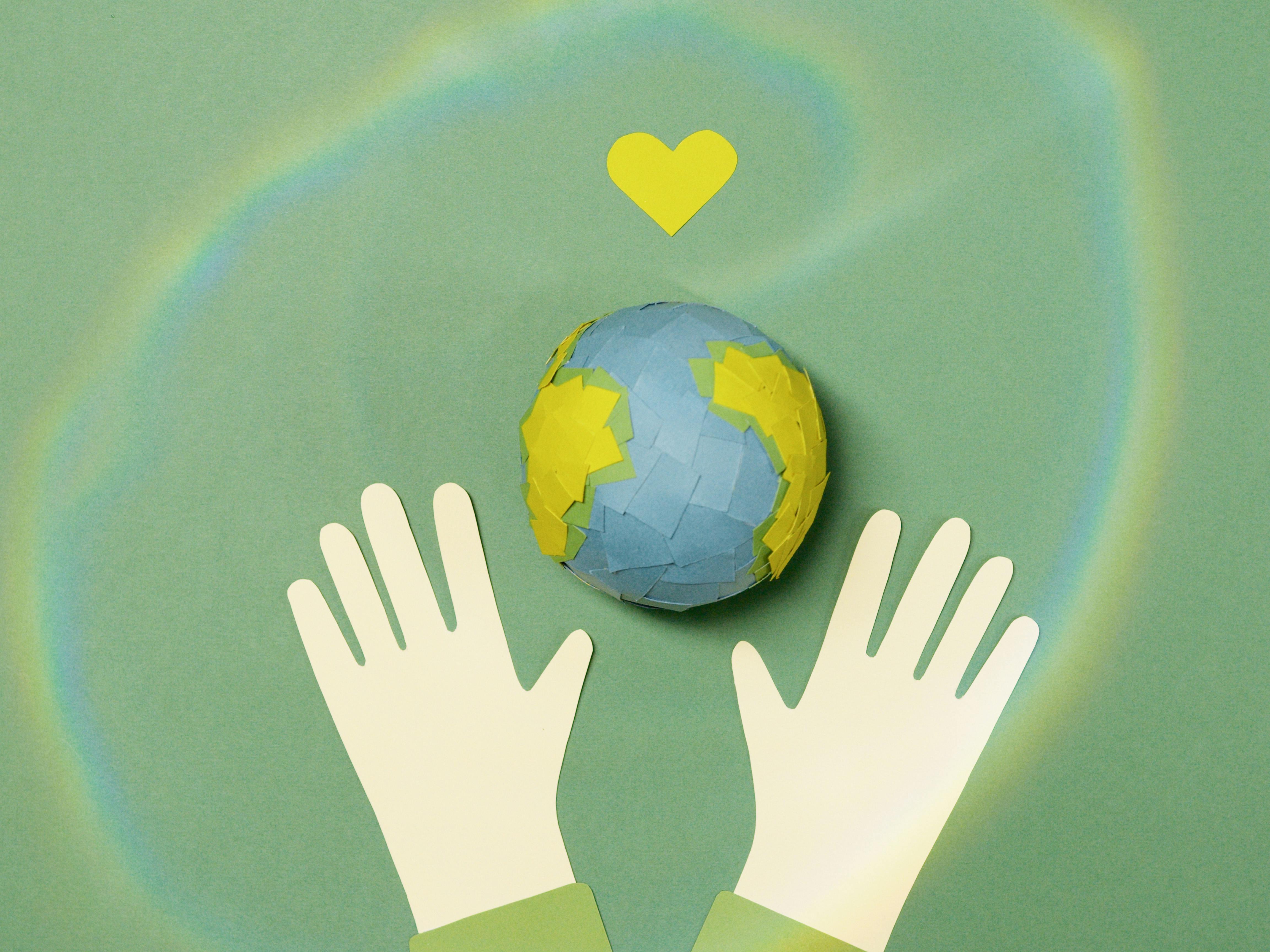image of earth with a heart above it and gloved hands below